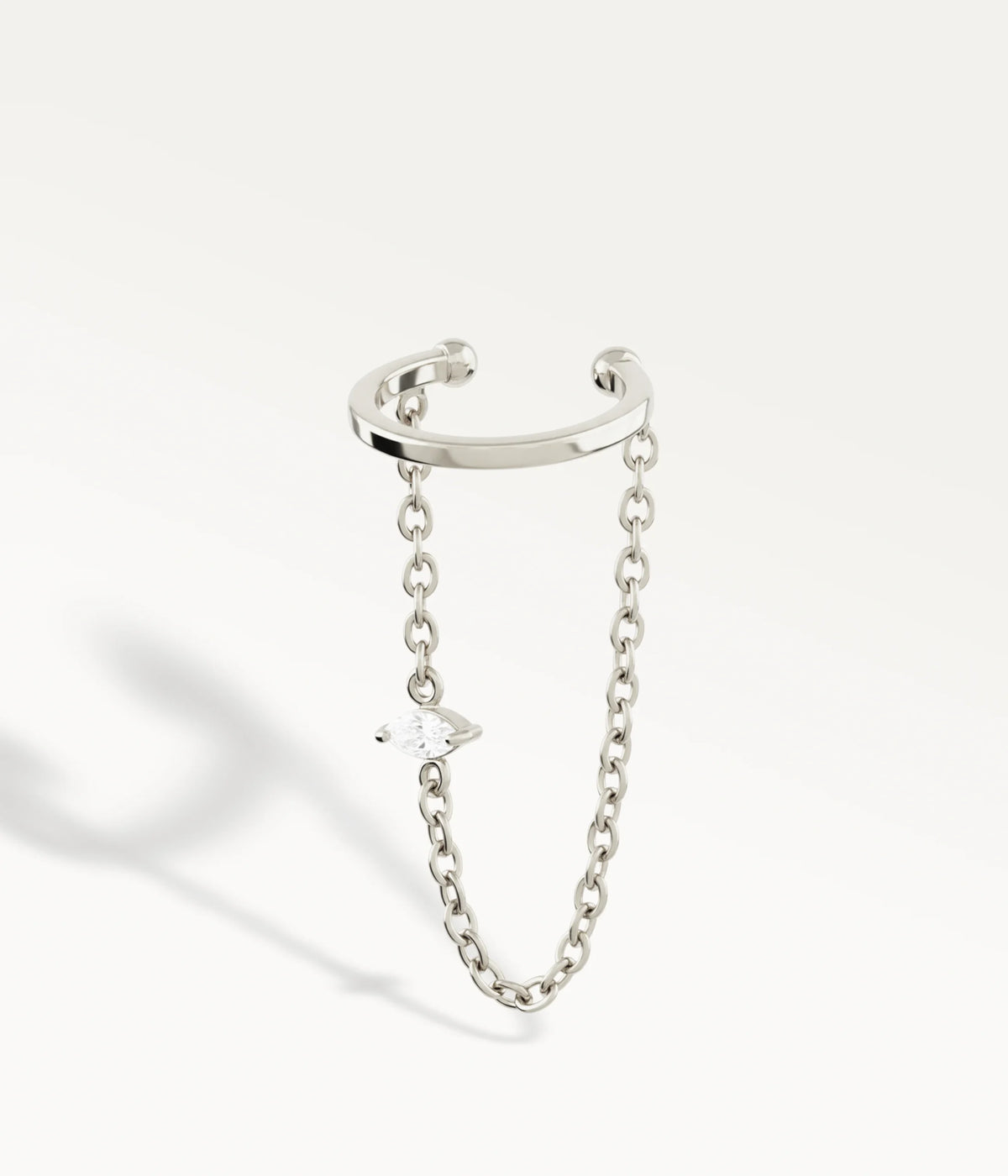 SilverfÀrgad Lia-ear cuff, öppen ring med hÀngande kedja och liten sten.