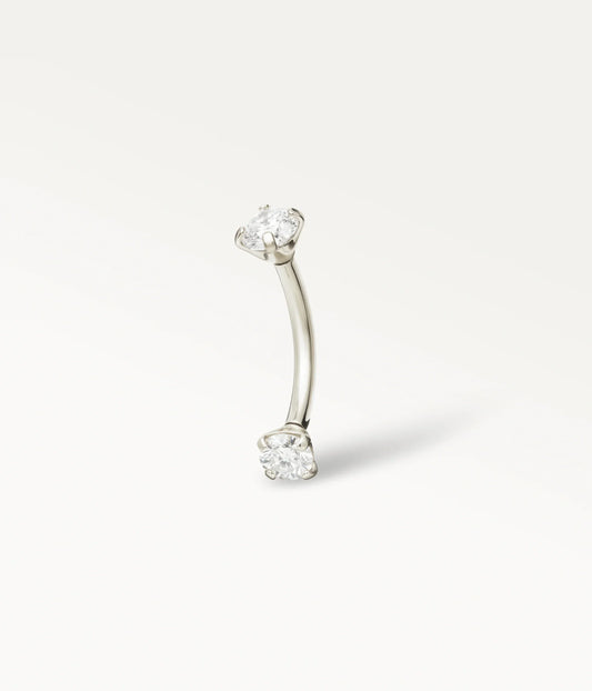Silver-tone Sceptre curved barbell with two round stones at the ends, three-quarter view.