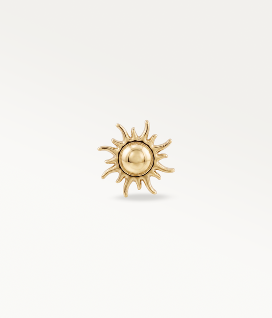 Helios doré en forme de soleil, avec centre rond et rayons ondulés, vue de face.
