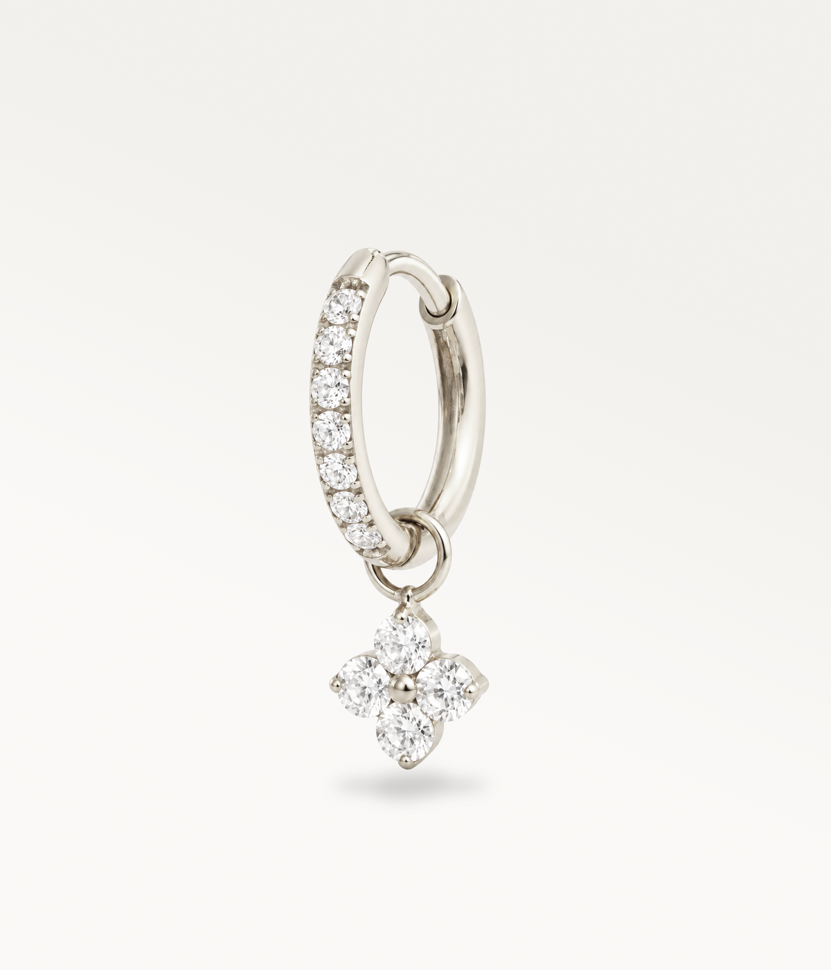 Silver-tone Poésie hoop earring with rhinestones and a four-stone pendant, three-quarter view.