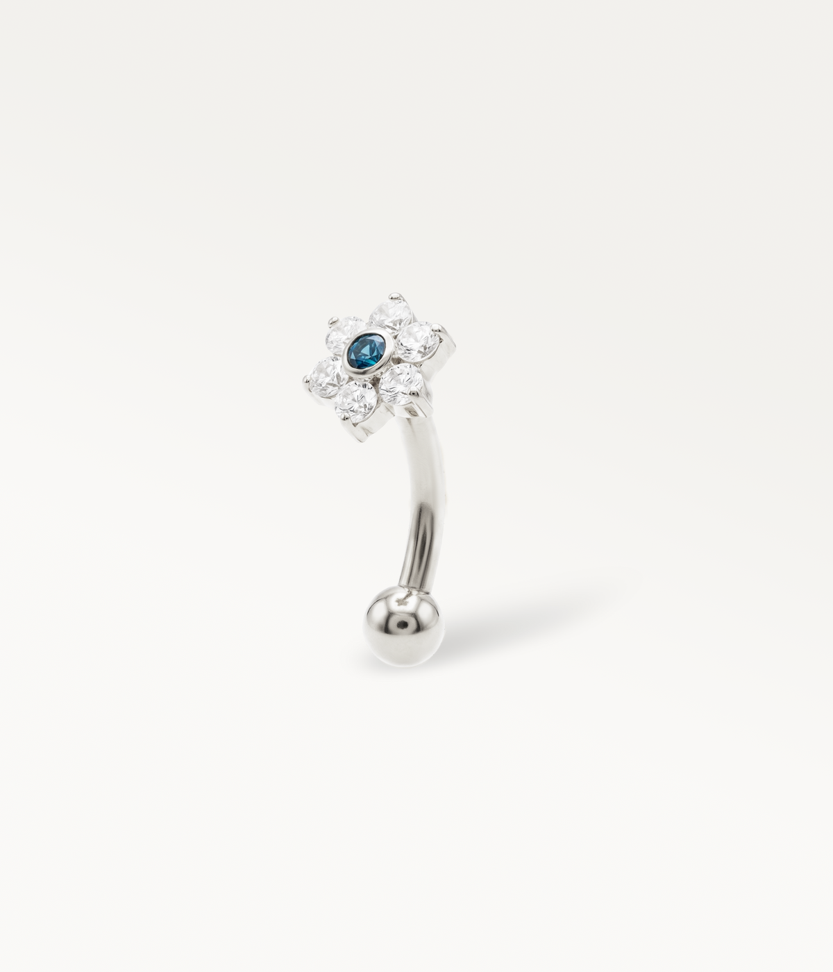 Jolane Bleu, gebogener Barbell, silberfarben, Blume mit blauem Mittelstein an gebogenem Stab, Seitenansicht.