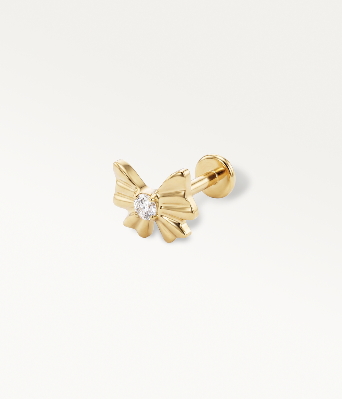 Gold-tone Noeud d’Or stud with a ribbon and central stone, detail of the flat-back post.