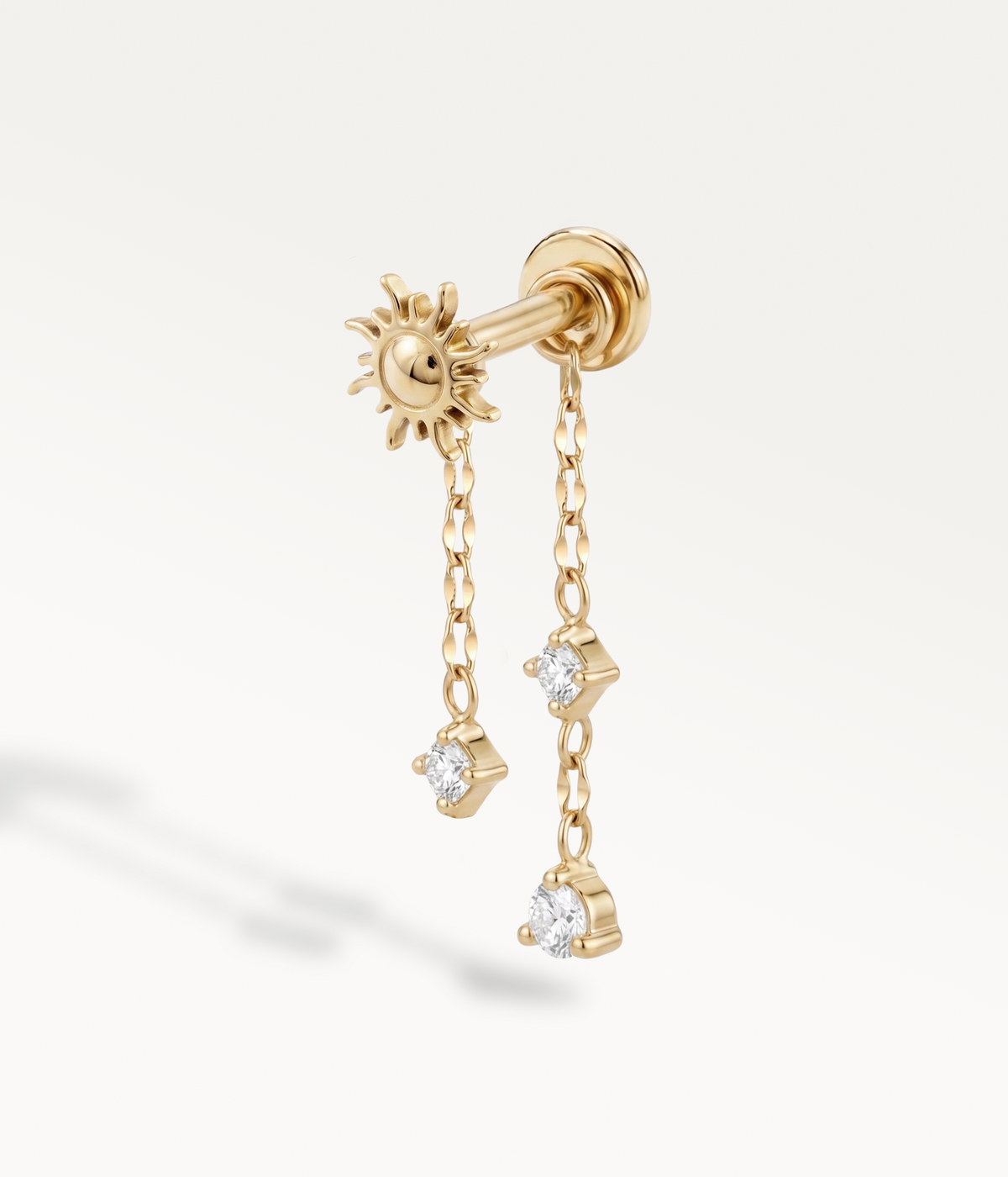 Helios color oro accompagnato dalle catene Astrid e Stella con pietre pendenti.
