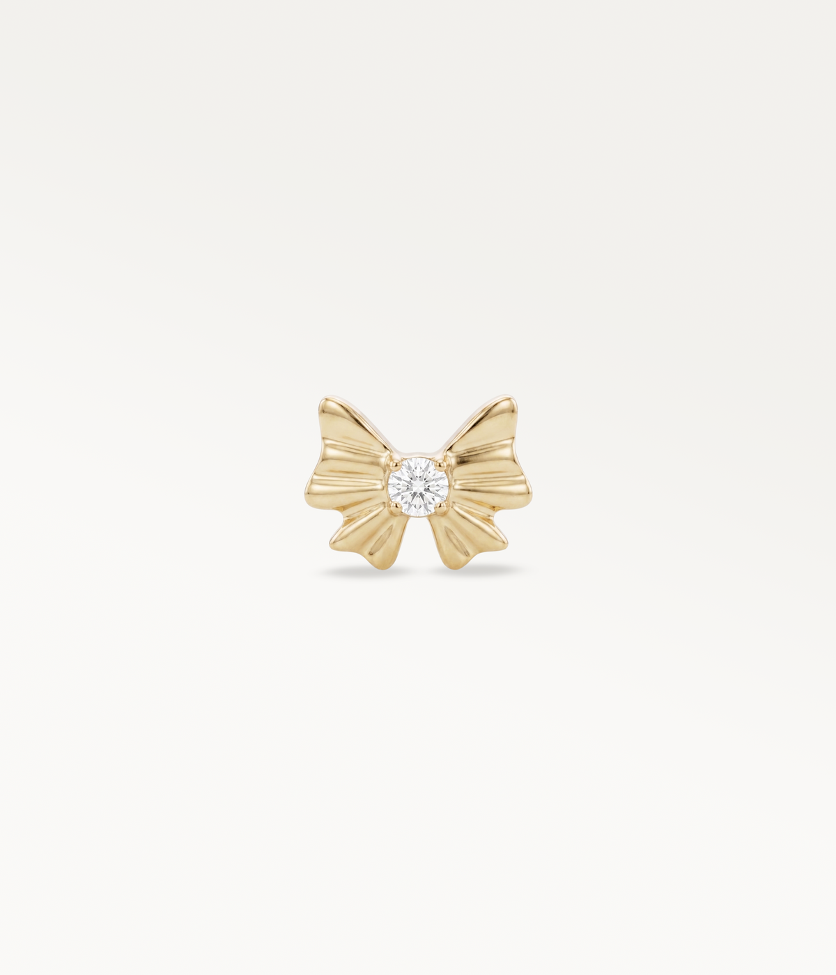 Gold-tone Noeud d’Or, tied ribbon design with a central stone, front view.
