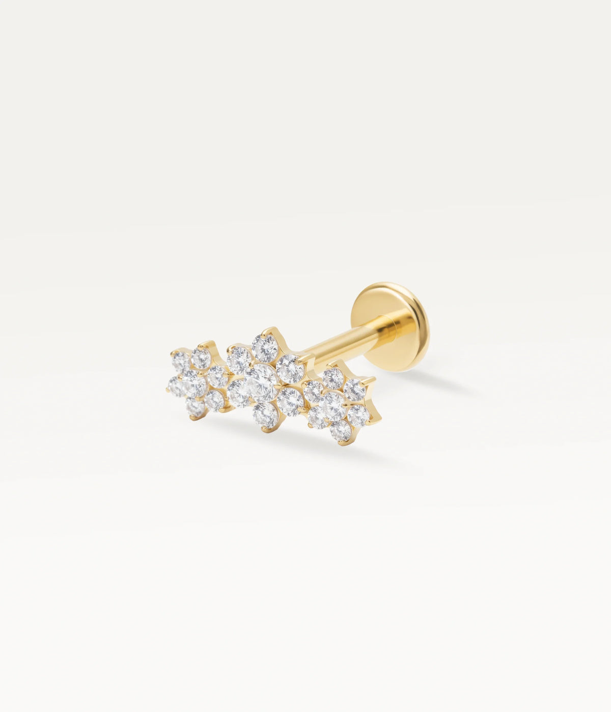 Gold-tone piercing jewellery with a floral constellation motif set with multiple sparkling zircons