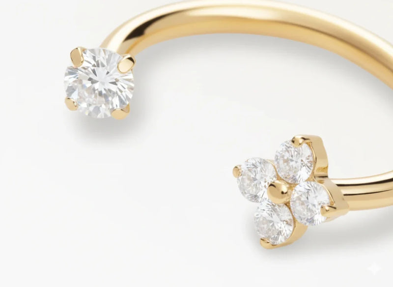 Piercing fer à cheval doré orné d’une fleur sertie de zircons, vue en gros plan élégante