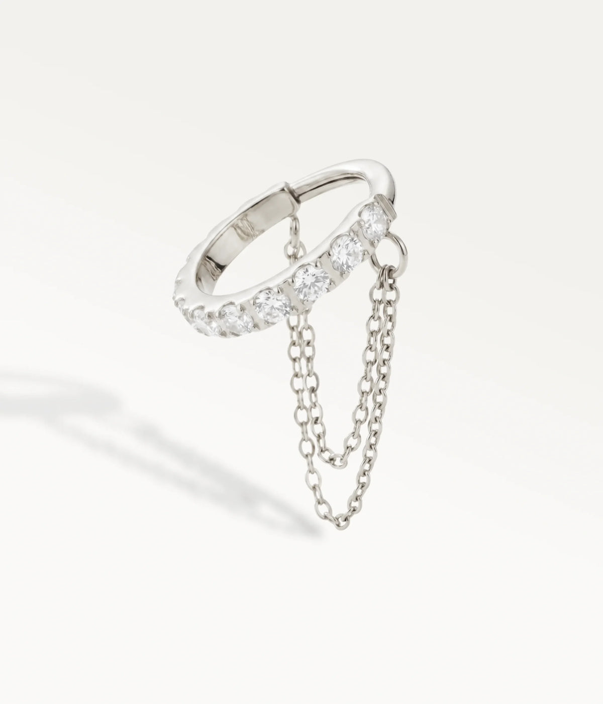 Piercing de helix con aro plateado engastado con piedras brillantes y doble cadena, vista en contrapicado