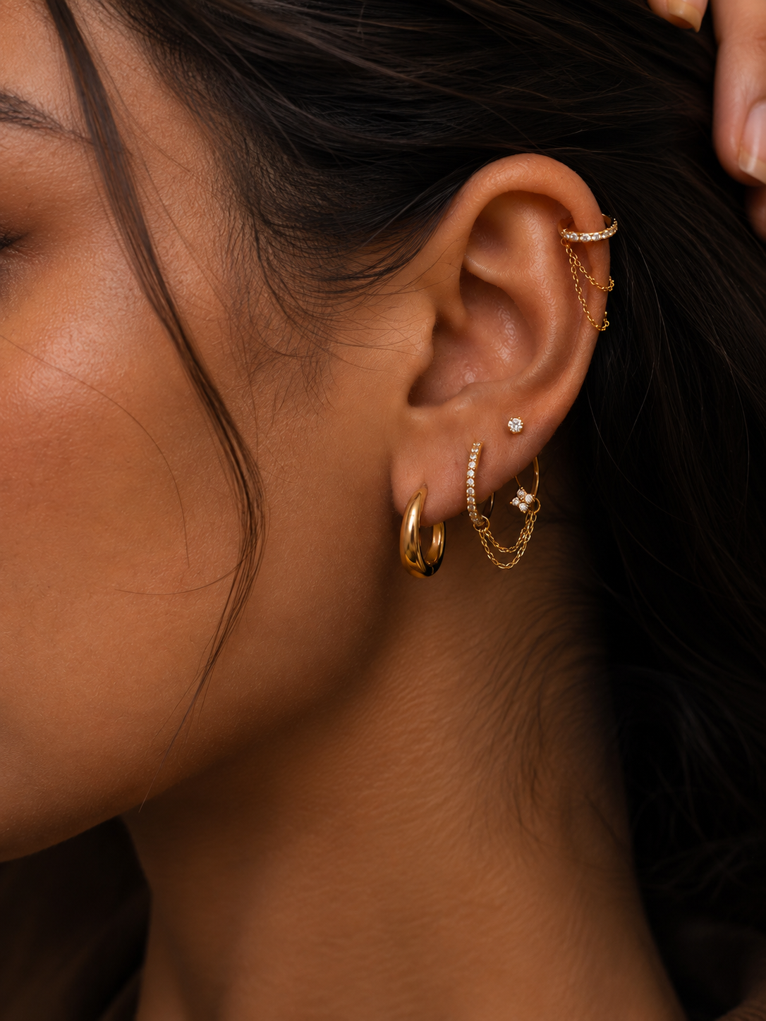 EverGold ear stack being worn, with gold-tone hoops and a chain linking the jewellery on the lobe.