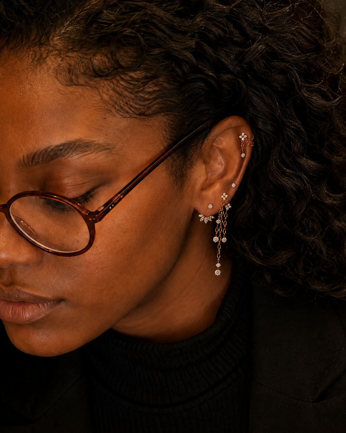 Portrait avec lunettes et composition de petites pierres et chaînes à l’oreille.