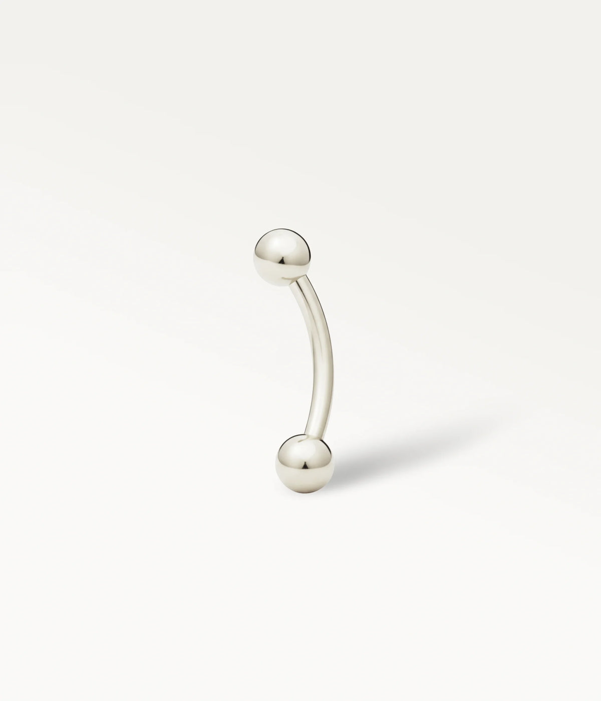 Piercing Bérénice color argento, con barretta curva terminata da due sfere lisce.