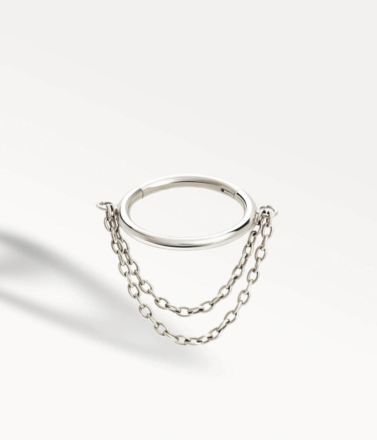 Silver-tone Élyra hoop with two fine hanging chains, three-quarter view.