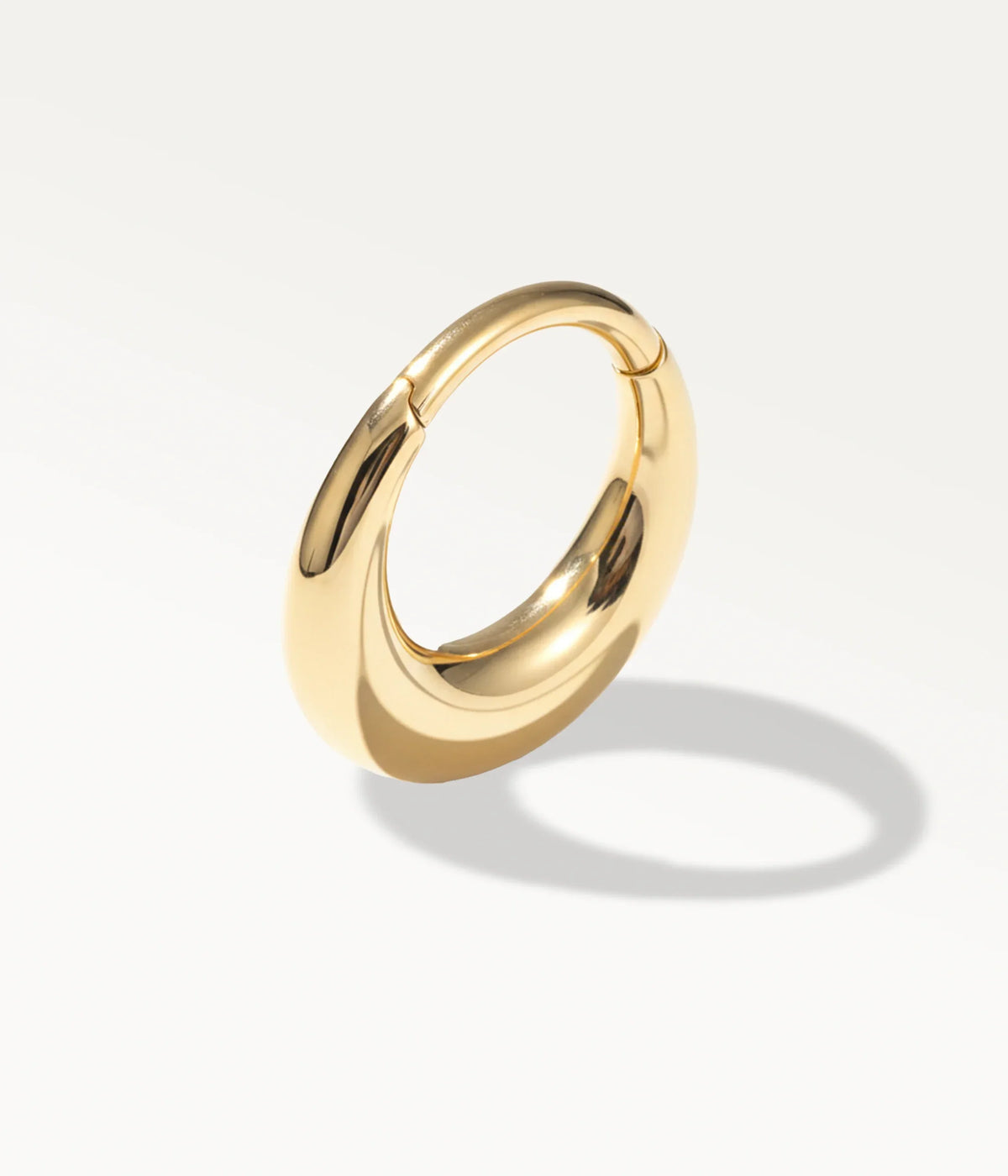 Smooth domed gold-tone Halo hoop, angled view with its shadow.