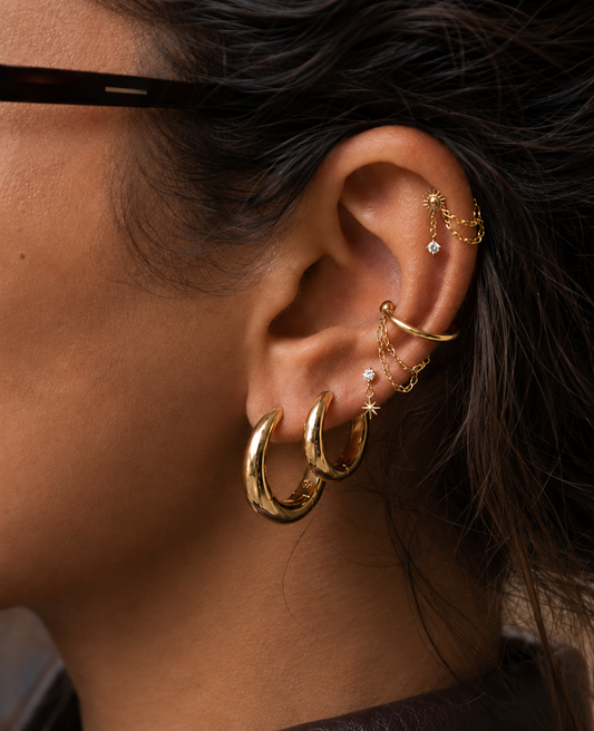Composition Agathe portée, avec créoles dorées au lobe et chaînes sur le cartilage.