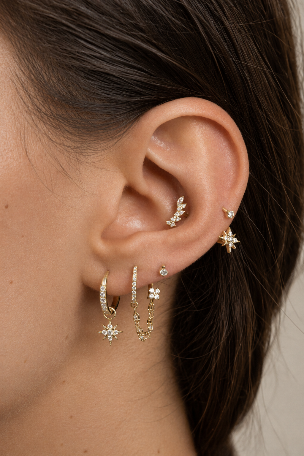 Orée ear stack being worn, with gold-tone hoops with star pendants and stones at the conch.