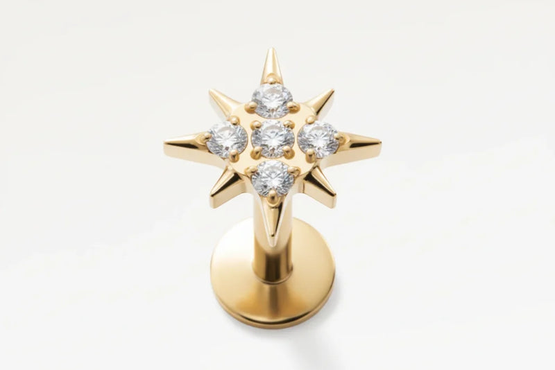Gros plan sur piercing stud doré en forme d’étoile sertie de zircons